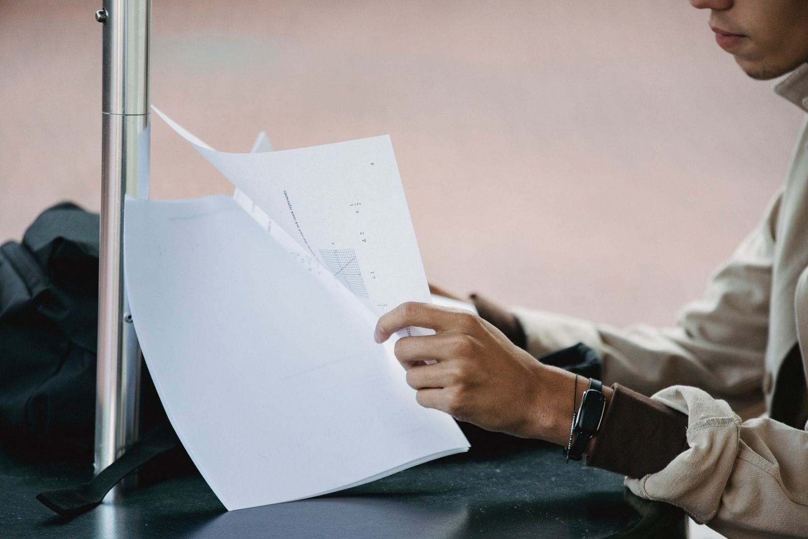 A student reading printed pages at a table