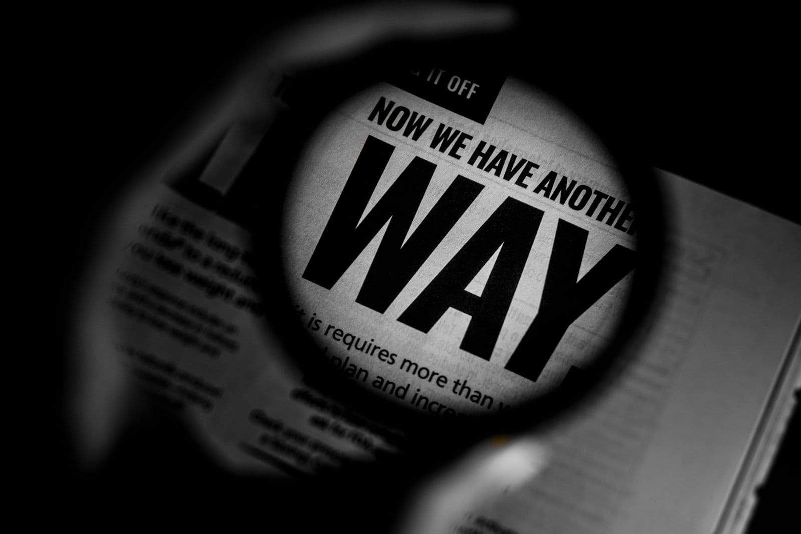 Black and white close-up of newspaper text magnified through a lens